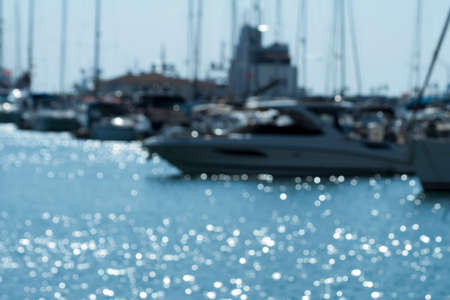 Blurred marine background with blue sea, boats and sparkling bokehの写真素材