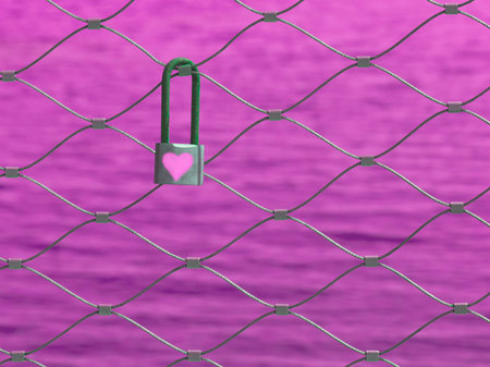 Small love lock hanging on metal fence on pink backgroundの写真素材