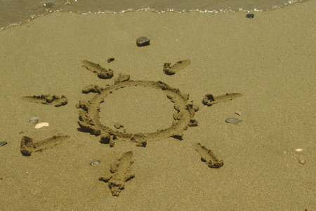 Sun shape drawing on beach sand