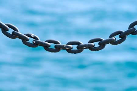 Close-up of gray metal chain on blue background