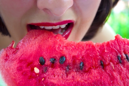 A young woman eating a red, ripe watermelon,photographyの写真素材