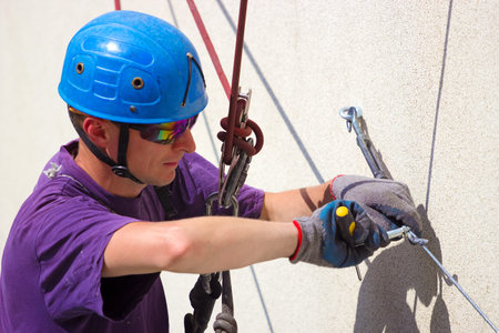 Worker at height ; Specially equipped worker performs height work,photography