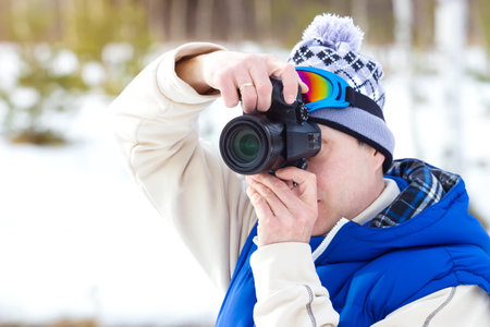 Winter sports Photographer ; A young man in ski gear with a camera photographed winter landscapes...