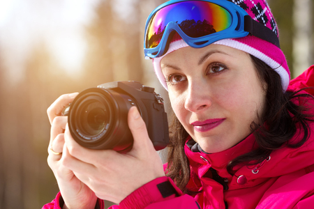 Winter sports photographing ; A beautiful woman with a camera photographed winter sportsの写真素材
