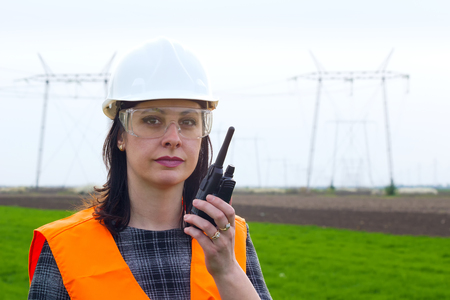 Female engineer electrician ; Supervising female engineer for electrification using walkie- talkies near the transmission lineの写真素材