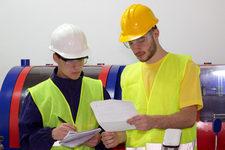 Two young mechanical workers ; Two young engineers are studying work plansの写真素材