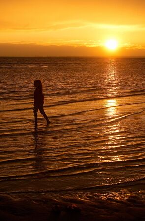 a little girl looking at the setting sun after storm の写真素材