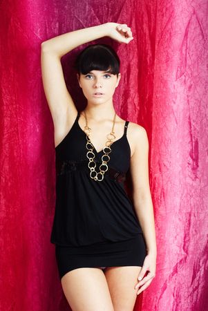 brunette fashion girl standing on the pink and purple background in a teasing poseの写真素材