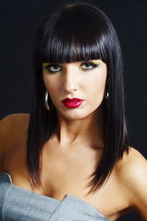 elegant brunette woman posing on dark background - close upの写真素材