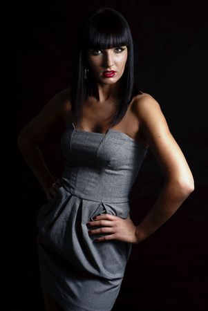 elegant brunette woman posing on dark backgroundの写真素材