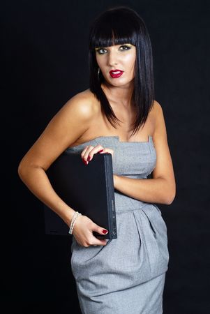 pretty woman with laptop on dark backgroundの写真素材