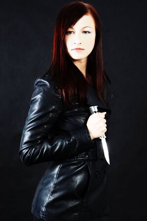 Woman in black holding a knifeの写真素材