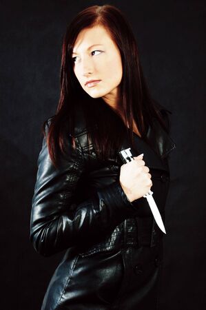 Woman in black holding a knifeの写真素材