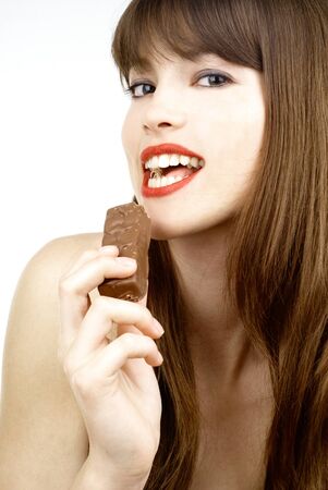 beautiful girl biting a bar of chocolate in a sexy wayの写真素材