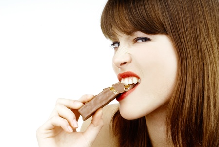 beautiful girl biting a bar of chocolate in a sexy wayの写真素材