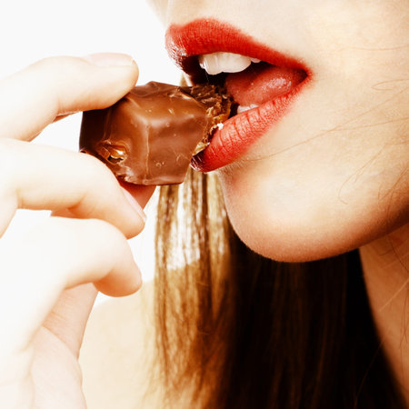 close up of woman's lips biting a chocolate bar