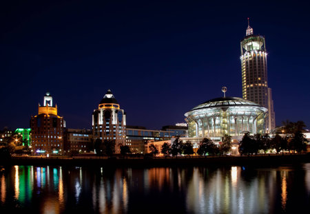 View of the Red Hills Swissotel hotel and Moscow International House of Music over the Moscow-river at nightの写真素材