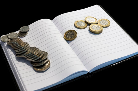 coins on notebook with black background.money conceptの写真素材