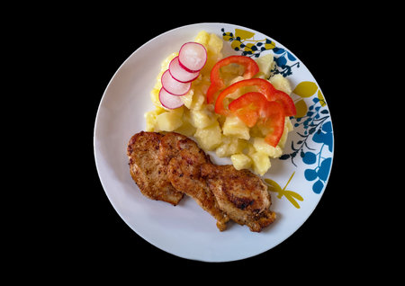 Grilled steaks, baked potatoes and vegetables on black backgrounds