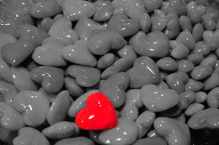 Red polished heart shaped stone among other gray heartsの写真素材