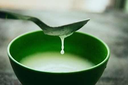 Milk being mixed in a bowl with a spoonの写真素材