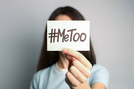 Woman holding card with hashtag MeToo in front of her face. Closeup viewの写真素材