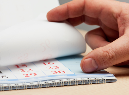 Hand leafs the sheets of the calendarの写真素材