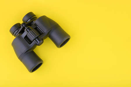 Binoculars on yellow background top viewの写真素材