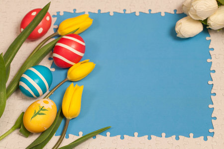 Painted eggs and yellow tulips on a blue background