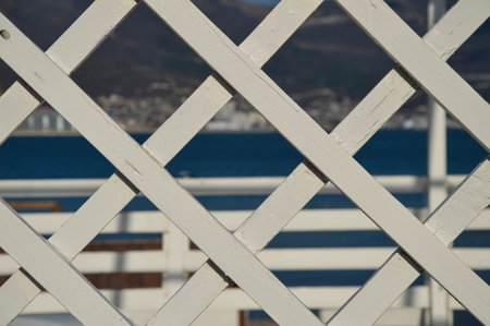 white wooden decorative grille and the sea in the backgroundの写真素材