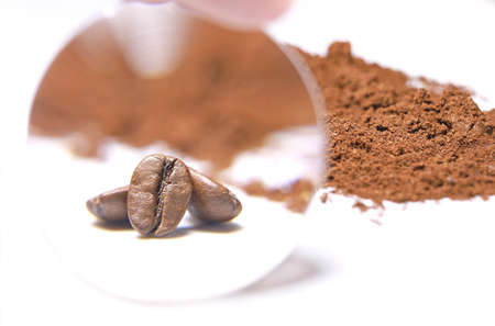 Arabica coffee beans and ground coffee. Coffee beans through magnifying glass. Medium roast coffee beans. Toning drink, natural energetic, morning aroma. Bean closeup.の写真素材