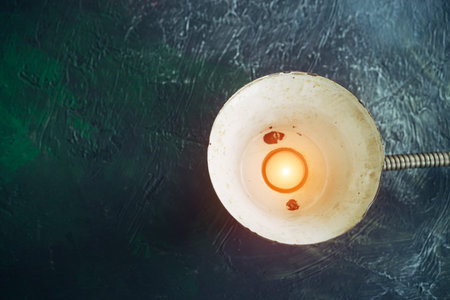 vintage metal lamp with a burning candle, on a green abstract background, the concept of the earth hourの写真素材