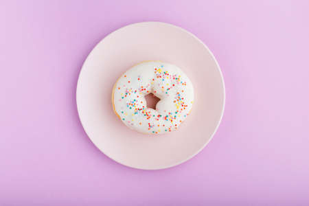 donut on a pink plate on a purple background  close-up ,top viewの写真素材