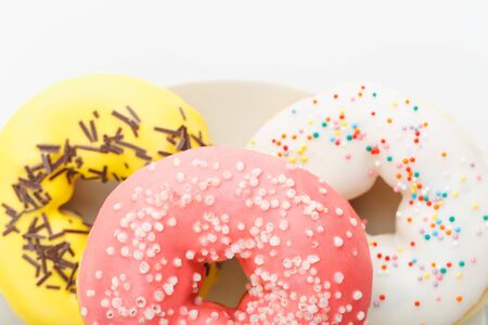 a bunch of donuts on a plate and on a white background close-upの写真素材