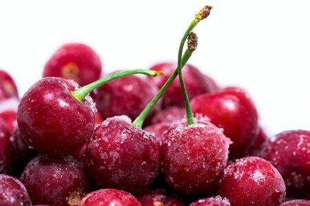 group of frozen cherries on a white background . close-up of berries. ice crystals on the fruit.の写真素材