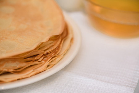 Maslenitsa is a holiday at the end of February . pancakes with sour cream, honey and milk on a light...