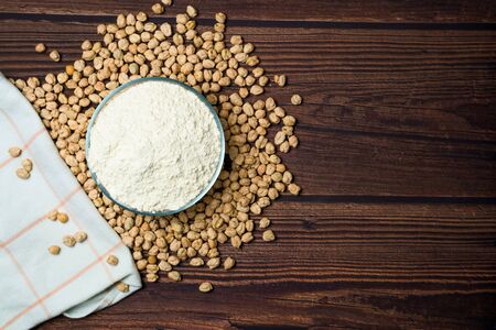 chickpea flour. organic healthy cereals. flour in a plate on a wooden background. natural vegetarian vegetable protein . the view from the top, place for text.の写真素材