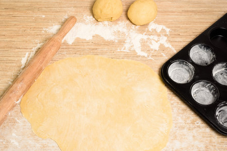 rolled dough with butter on the table with a rolling pin for rolls and rolls. next to it is a...