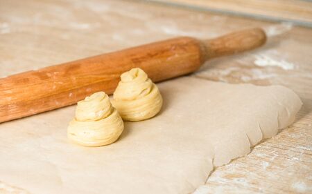 raw cruffins before baking in the oven. puff pastry croissant similar to a muffin rolled into a roll. modern baking. close-up, space for text. horizontal frame.の写真素材
