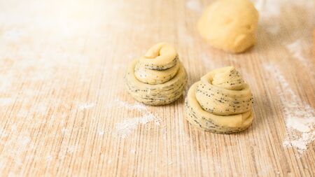 raw cruffins before baking in the oven. puff pastry croissant similar to a muffin with poppy seeds. modern baking. close-up, space for text. the horizontal frameの写真素材