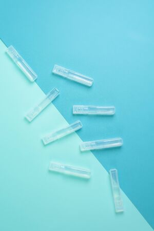 liquid vaccine in a transparent flask from the coronavirus virus on a blue background . the view from the top . treatment of infection in a pandemic.の写真素材