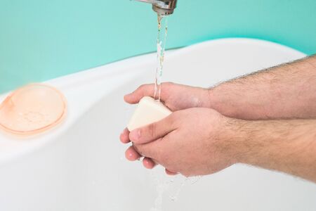 washing and disinfecting hands from germs and viruses with soap and water on a blue background.の写真素材