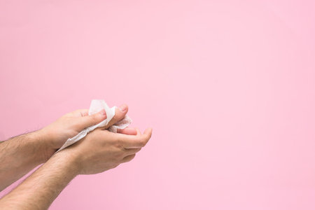 antimicrobial napkin for hand disinfection during a coronavirus pandemic. on a pink background. space for text.の写真素材