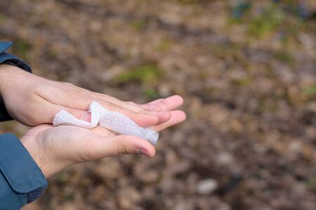 antibacterial treatment of hands before eating in nature. the man wipes his hands with a damp cloth from viruses and bacteria. human anti-coronavirus protection.の写真素材