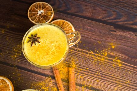 Golden turmeric milk drink with turmeric powder and ingredients in a clear glass on a dark background. A traditional Indian drink is turmeric milk. The view from the top, space for text.の写真素材