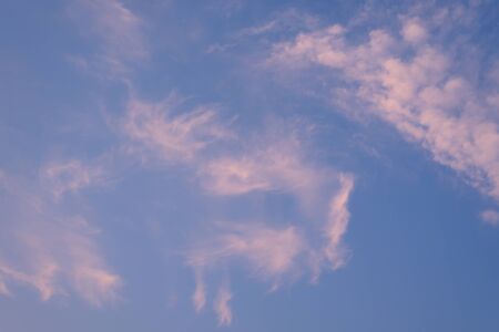 pink pastel clouds at sunset blue sky. abstract photo, background imageの写真素材