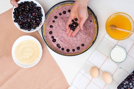 the stages of preparation of a pie with black currants and shortbread crust , fresh berries. the view from the topの写真素材