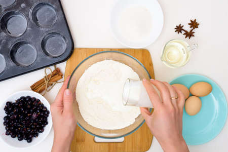 step by step recipe for muffins with black currants . preparing the dough, mixing the ingredients of flour, butter, sugar, eggs, vanilla, currant. the view from the topの写真素材