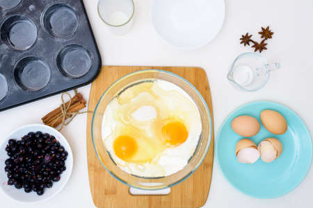 step by step recipe for muffins with black currants . preparing the dough, mixing the ingredients of flour, butter, sugar, eggs, vanilla, currant. the view from the topの写真素材