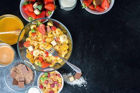 mini pancake cereal bowl with fresh strawberries banana chocolate, coconut shavings and honey in small plates. the view from the top . the trend of self-isolation.の写真素材